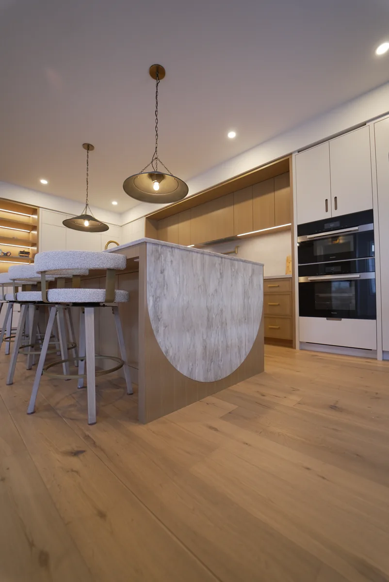 Close view of a pale stone waterfall edge on a warm wood kitchen island