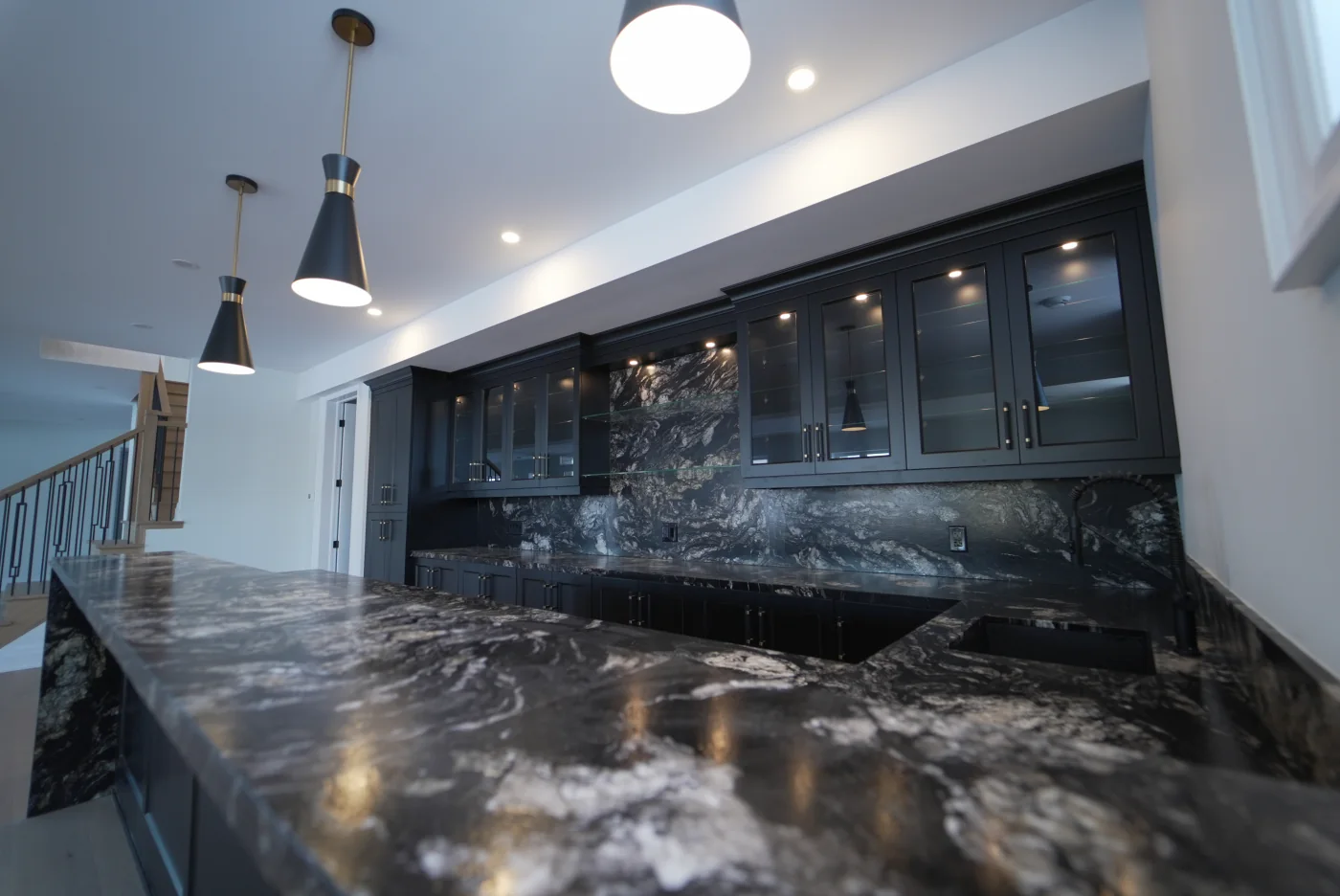 Black stone countertop and matching full-height backsplash fabricated by Eco Stone